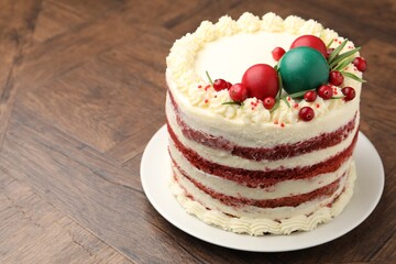 Delicious sponge cake with Christmas decor and red currants on wooden table, closeup. Space for text