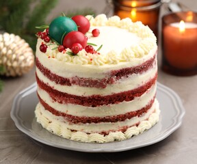 Delicious sponge cake with Christmas decor and red currants on grey textured table, closeup