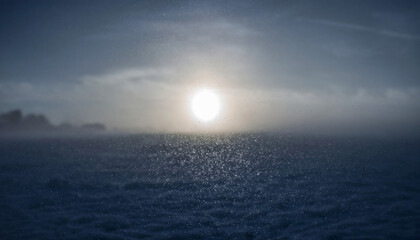 Sunset over a calm sea with foggy horizon and blue sky