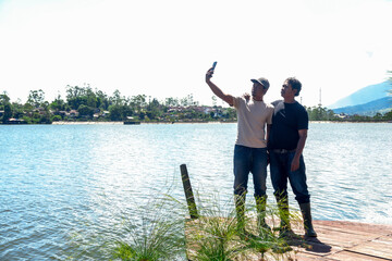 Two Friends Capturing Memories With Lakeside Selfie on Summer Day