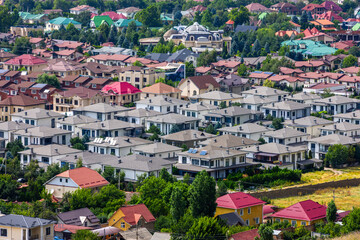 Charming residential houses line a peaceful suburban street under bright sunshine in Bishkek city,...