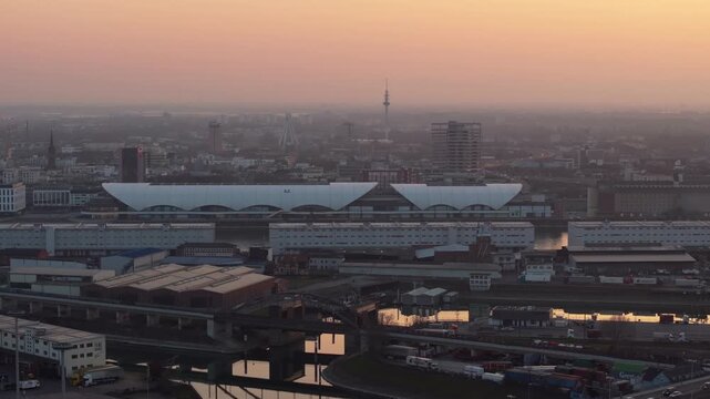 Urban landscape of Mannheim, Germany, from a high angle perspective at dusk. Central train station and city buildings under a warm, hazy sky
