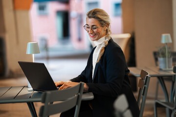 Stylish professional woman focused on laptop in cozy evening office showing modern leadership and...