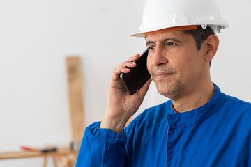 Phone call, construction worker and man at warehouse for building, laugh and maintenance. Mobile, engineer and conversation for inspection, industrial architecture and happy with development indoor