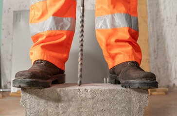 Worker was drilling rocks, and wearing safety shoes to protect his feet at building