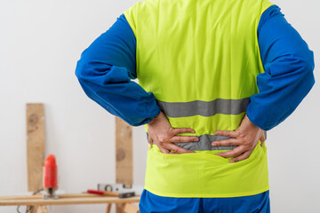 Man, architect and hands in back pain, accident or posture after construction injury on site. Rear view of male person, contractor or engineer with sore spine, muscle or bruise from building.