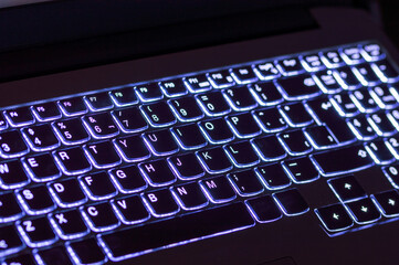 Closeup of laptop blue keyboard illumination, backlit keyboard