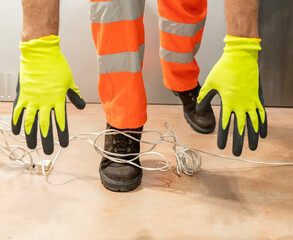 An industrial safety topic. A worker tripping over an electrical extension cord in an industrial environment at factory.