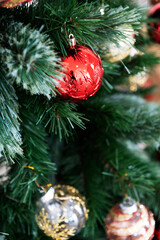 Embossed red Christmas ornament hanging on tree