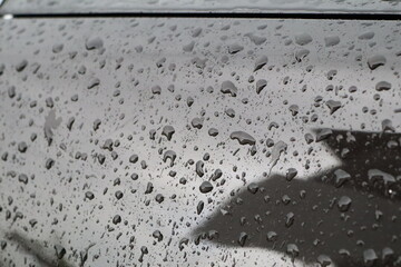 dark cityscape emphasizing water droplets on window and solitary umbrella against moody overcast sky