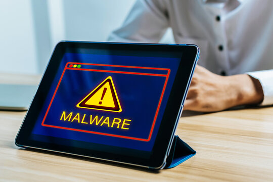 Malware Detection Alert. digital mobile tablet with with virtual malware attack warning graphic on desk, cybersecurity, data privacy, virus protection software, internet network technology concept