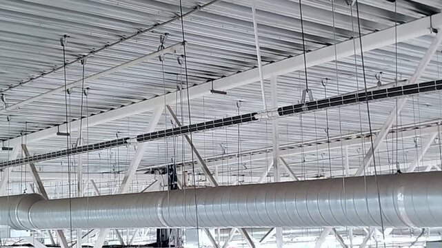 Industrial ceiling with HVAC duct and cable trays even light and metal textures camera movement left to right suitable for warehouse retail and infrastructure b roll