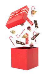 Christmas celebration. Candies falling into gift box on white background