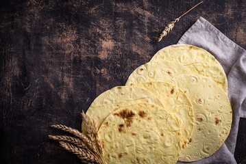 Lavash flat bread on green background