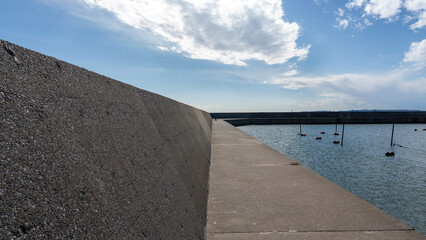 Long Concrete Breakwater under Clear Blue Sky