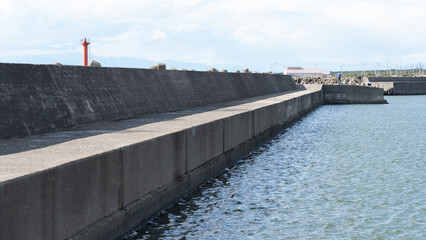 Long Concrete Breakwater under Clear Blue Sky