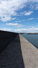 Long Concrete Breakwater under Clear Blue Sky