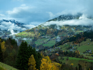 hameaux dans les alpages alpins avec lignes de nuages, neige d'altitude et for&ecirc;ts d'&eacute;pic&eacute;as et de feuillus. Massif du beaufortain
