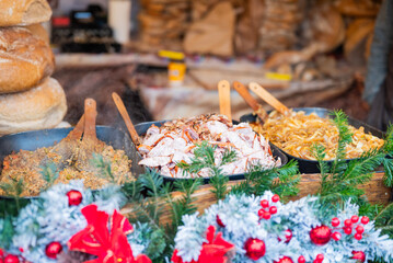 vendor fries meat and sausage on the grill in the city center at the Christmas market in Krakow Poland
