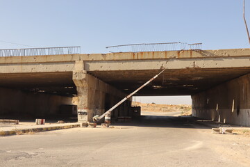 Abandoned former Syrian army checkpoint under a damaged bridge near Aleppo, Syria. symbolizing war’s end and the rise of freedom. Ideal for documentaries, news and archives on Middle Eastern conflicts