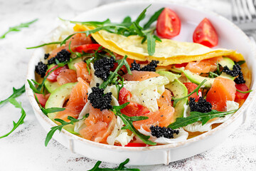 Healthy breakfast. Quesadilla with omelette, salmon, avocado, black caviar and tomatoes. Keto, ketogenic lunch.
