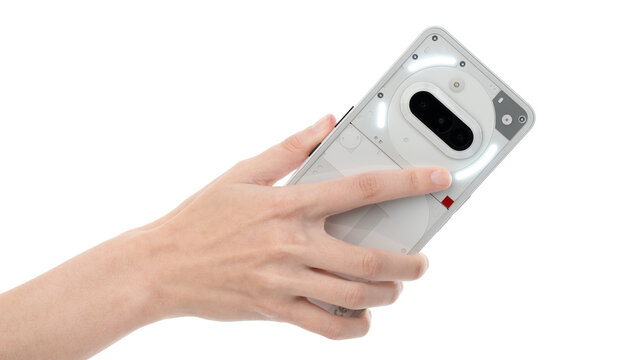 Dnipro, Ukraine 10.15.2025: Hand Holding Nothing Phone (3a) Smartphone with Translucent Back Panel on Clean White Background for Product Mockup