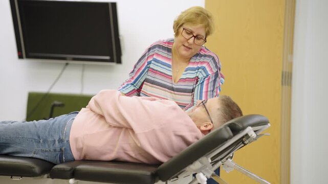 Kinesiology therapist performing muscle testing on patient
