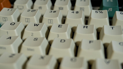 Close-up shot of QWERTY section on a mechanical keyboard, focus on E and R keys with gradual blur towards the front and back for depth emphasis.
