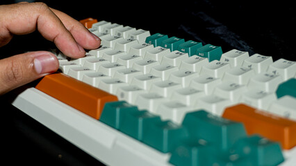Fingers resting on mechanical keyboard, keycaps in green and beige, front row keys sharp with progressive blur backward adding a realistic working mood.