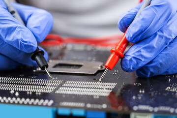 Technician under fixed and repairing computer mainboard process by used multimeter
