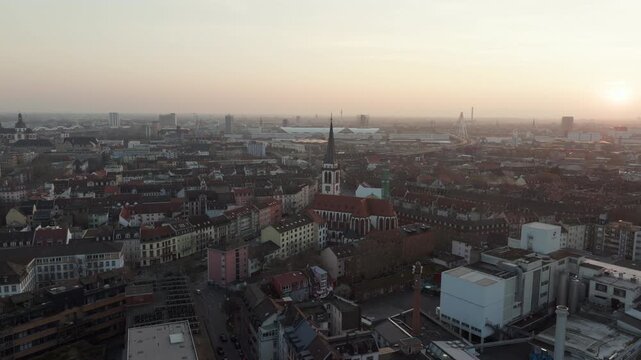 Hazy morning aerial view showing cityscape of Mannheim, Germany. Sun rises over the urban landscape with Jesuitenkirche church in the center