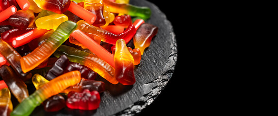 assorted jelly candies floating on black background