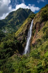 Fototapeta premium Dramatic Waterfall Cascading Down Rocky Cliff Face in Lush Green Mountainous Landscape Martinique France