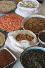 Bowls and bags full of various healthy grains and legumes. Selective focus.