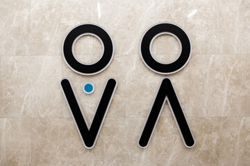 Triangle and circle as symbol on the wall marking the entrance to public restroom. Separation of men and women by gender in public spaces for privacy during toileting. Natural hygiene needs