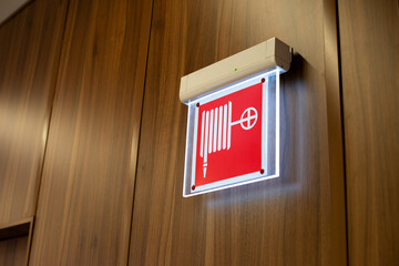 Illuminated sign indicating location of fire hydrant, hose and nozzle. Safe fire safety system. Providing public spaces with fire fighting equipment. Help with navigation in smoke filled room