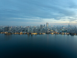 Naklejka premium Blue hour over West Lake with city lights shimmering across the calm water and expansive skyline.