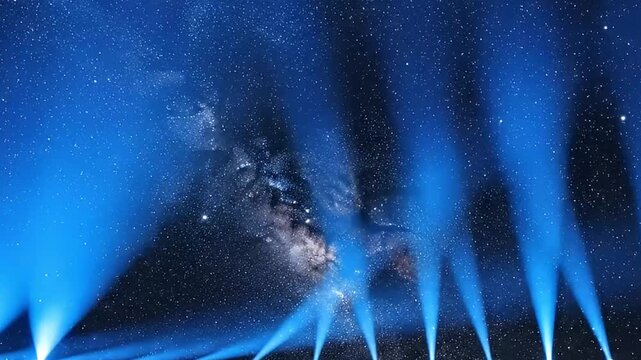 Striking blue light beams pierce through a dark, star-filled night sky, revealing a distant celestial body or galaxy. This dramatic and atmospheric visual evokes feelings of wonder, discovery, and gra