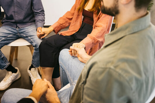 People holding hands in group therapy session