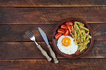 Homemade morning breakfast with fried egg, crispy potato and fresh tomatoes
