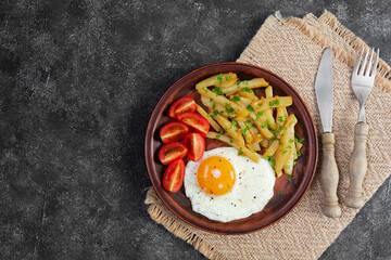 Homemade morning breakfast with fried egg, crispy potato and fresh tomatoes