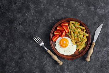 Homemade morning breakfast with fried egg, crispy potato and fresh tomatoes
