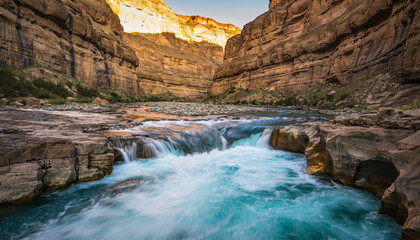 R&iacute;o fluyendo a trav&eacute;s de un ca&ntilde;&oacute;n rocoso o garganta. El agua desciende a trav&eacute;s de una serie de peque&ntilde;as cascadas y r&aacute;pidos. 