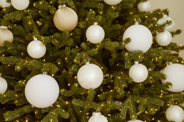 Christmas tree branch with decorations. Christmas background. Natural pine, white handmade balls