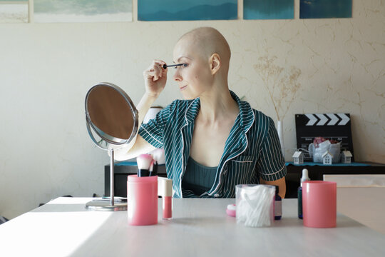 Cancer survivor doing daily makeup routine, showing skincare and cosmetic use for sensitive skin after chemotherapy.