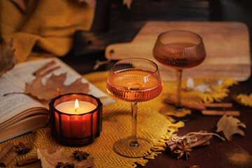 Cozy Autumn Setting with Rose Wine, Candle and Book