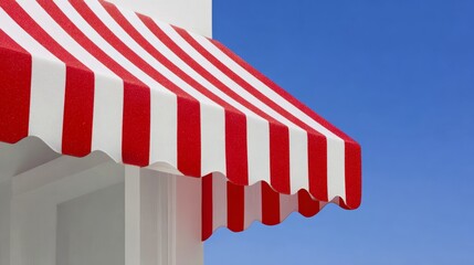 A red and white striped awning is on a building. The awning is open and the sky is blue
