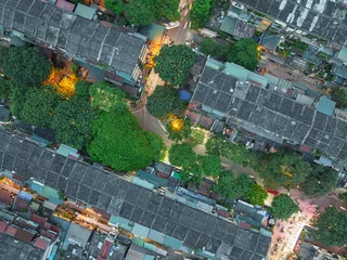 Fototapeten Enge Straßen Aerial view of narrow residential streets in Hai Ba Trung district, Hanoi, with green trees and warm evening lights.  © Hanoi Photography