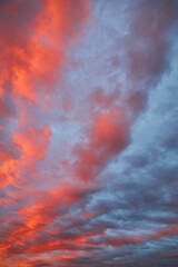 A dramatic sunset sky with a single fiery red cloud.