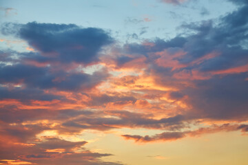 Beautiful sky with colorful golden and pink clouds at sunset.